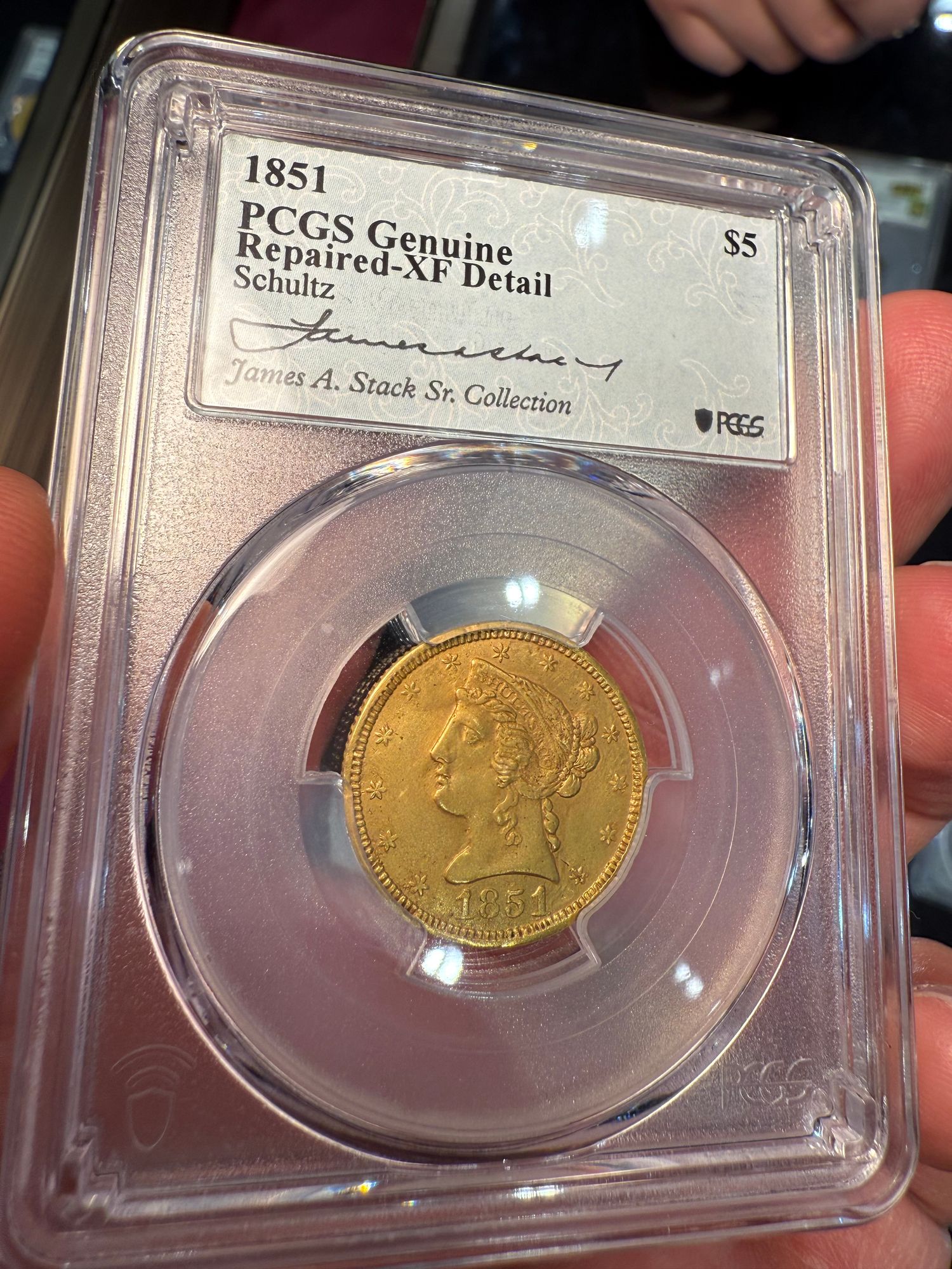 A gold (though damaged) Schultz $5 cousin